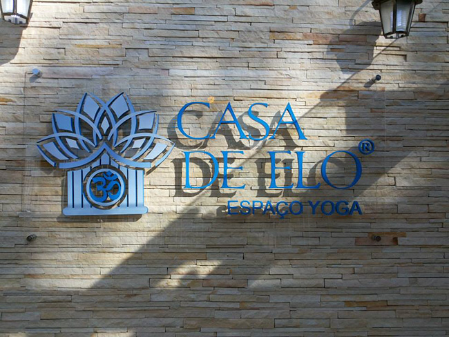 Visão frontal da placa em acrílico com a logo da Casa de Elo