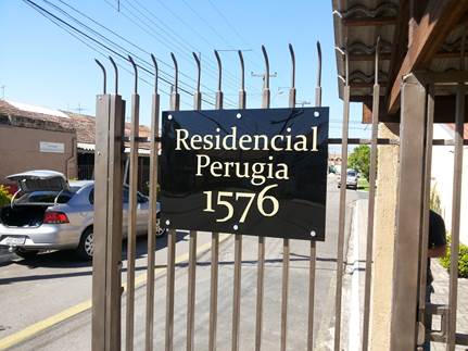 Visão do portão do condomínio com placa