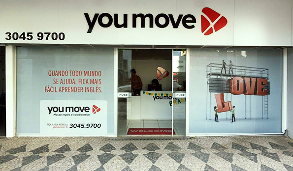 Visão frontal da fachada da escola com vitrines adesivadas